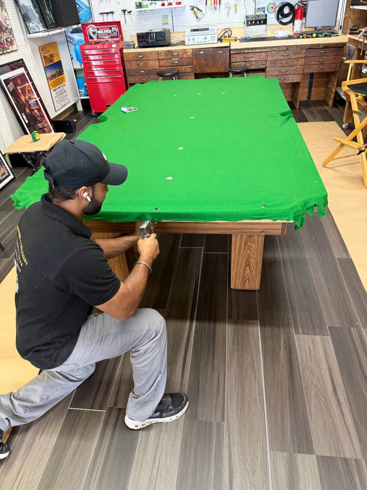 Technician carefully releasing pool table cloth