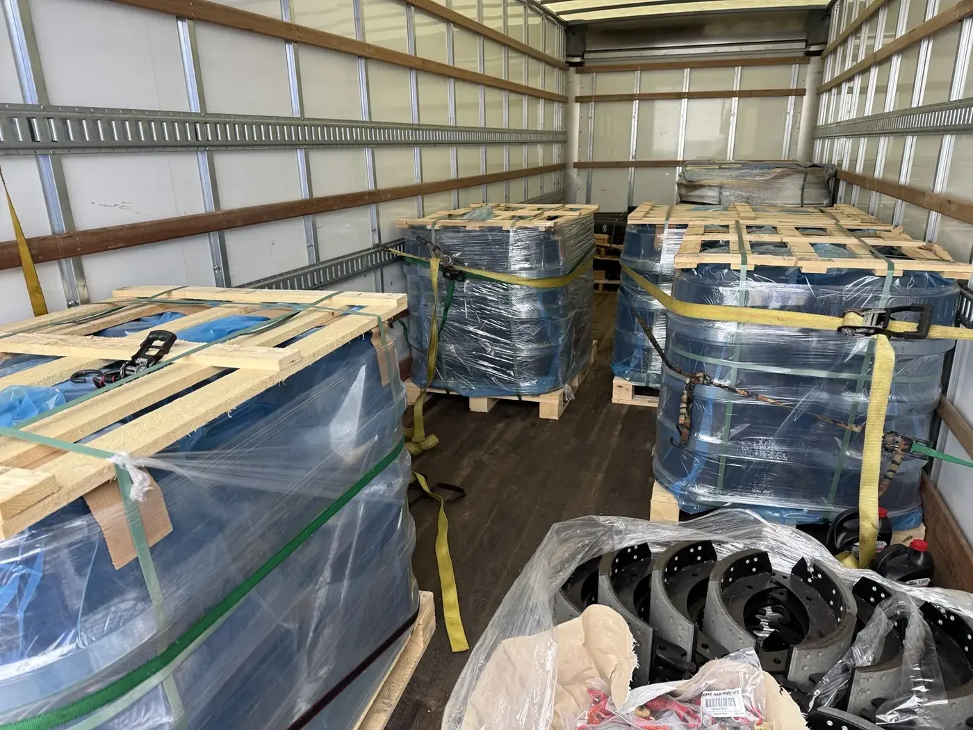 Commercial items wrapped and secured on pallets inside the moving truck