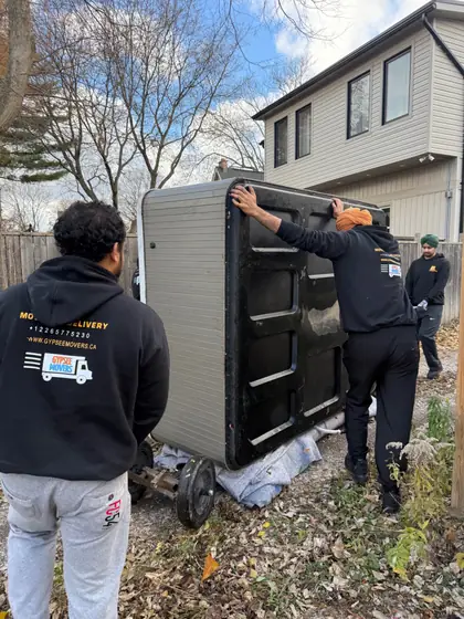 Gypsee Movers crew moving a hot tub through backyard access