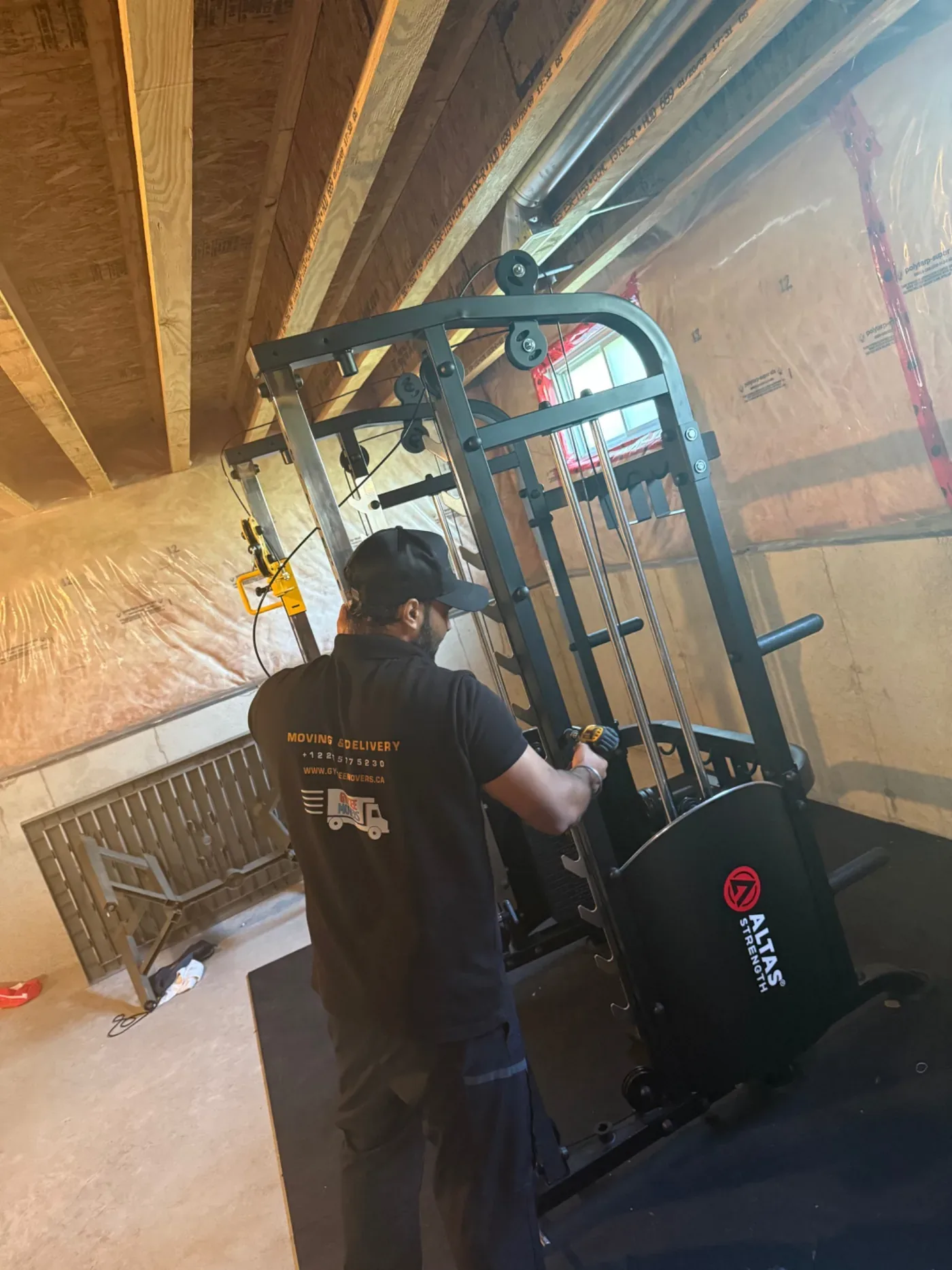 Gypsee Movers disassembling and assembling an Atlas Strength gym machine