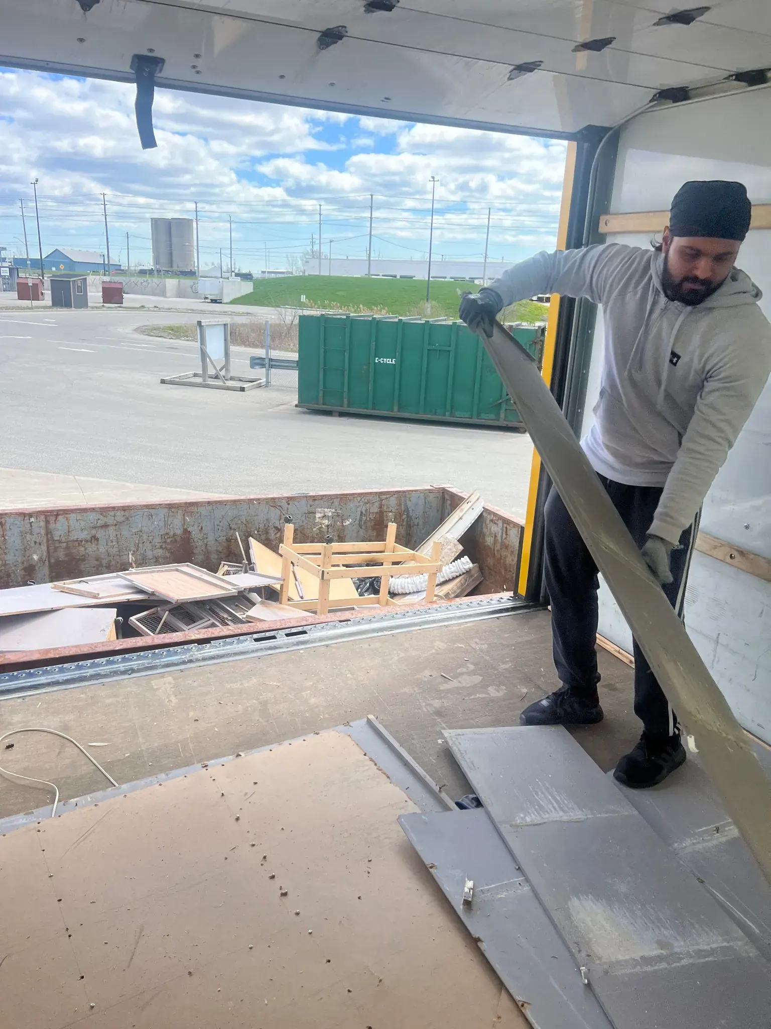 Worker loading junk into a disposal bin