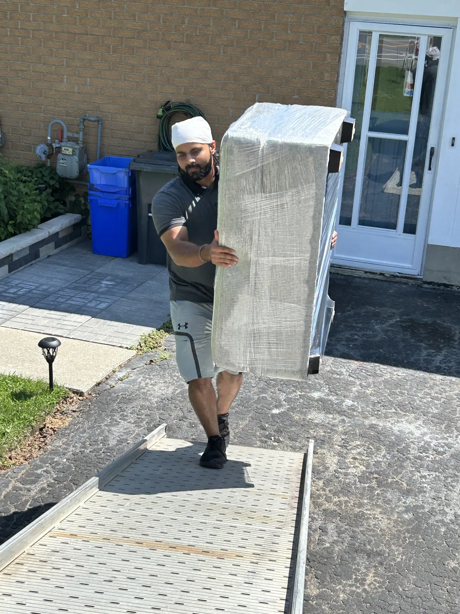 Gypsee Movers loading a wrapped furniture item into a truck