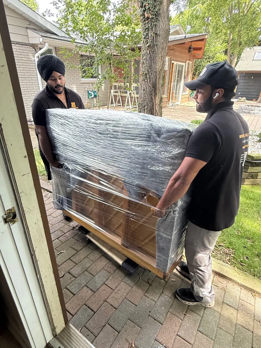 Upright piano protected with moving blankets and stretch wrap