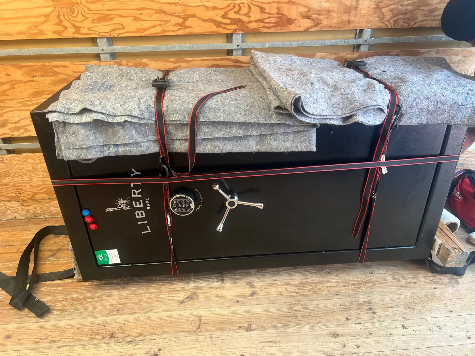 A large safe padded and strapped securely inside the moving truck