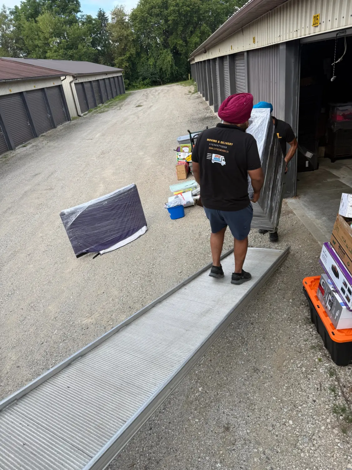 Movers handling a protected vending machine at a storage facility