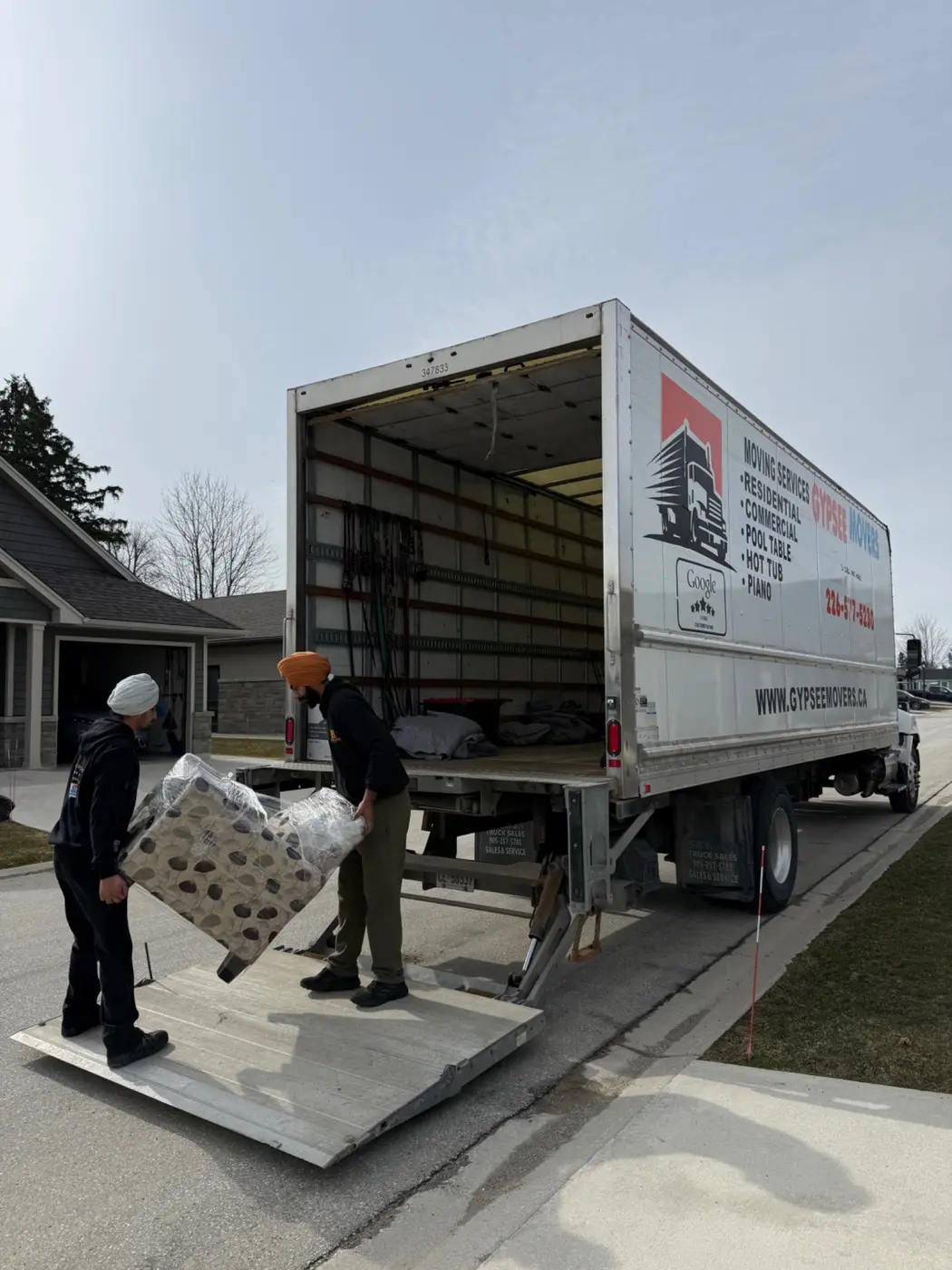 Gypsee Movers crew using hydraulic liftgate