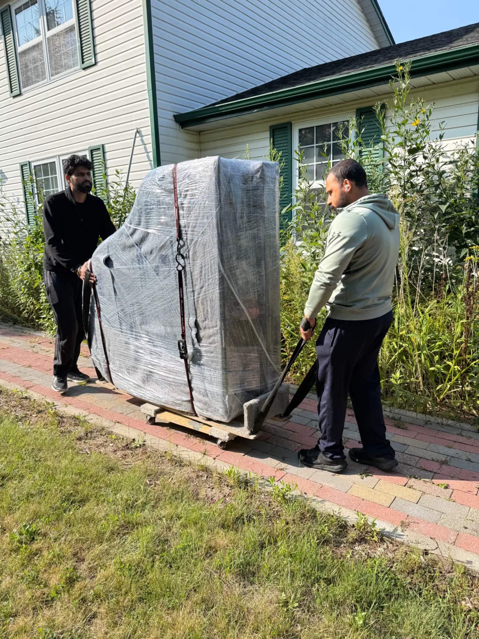 Gypsee Movers crew handling a wrapped piano