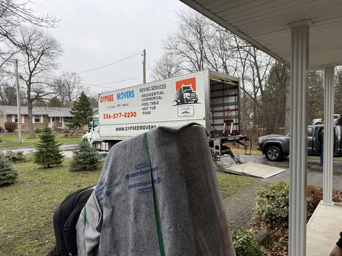Gypsee Movers piano movers preparing a protected piano near the moving truck