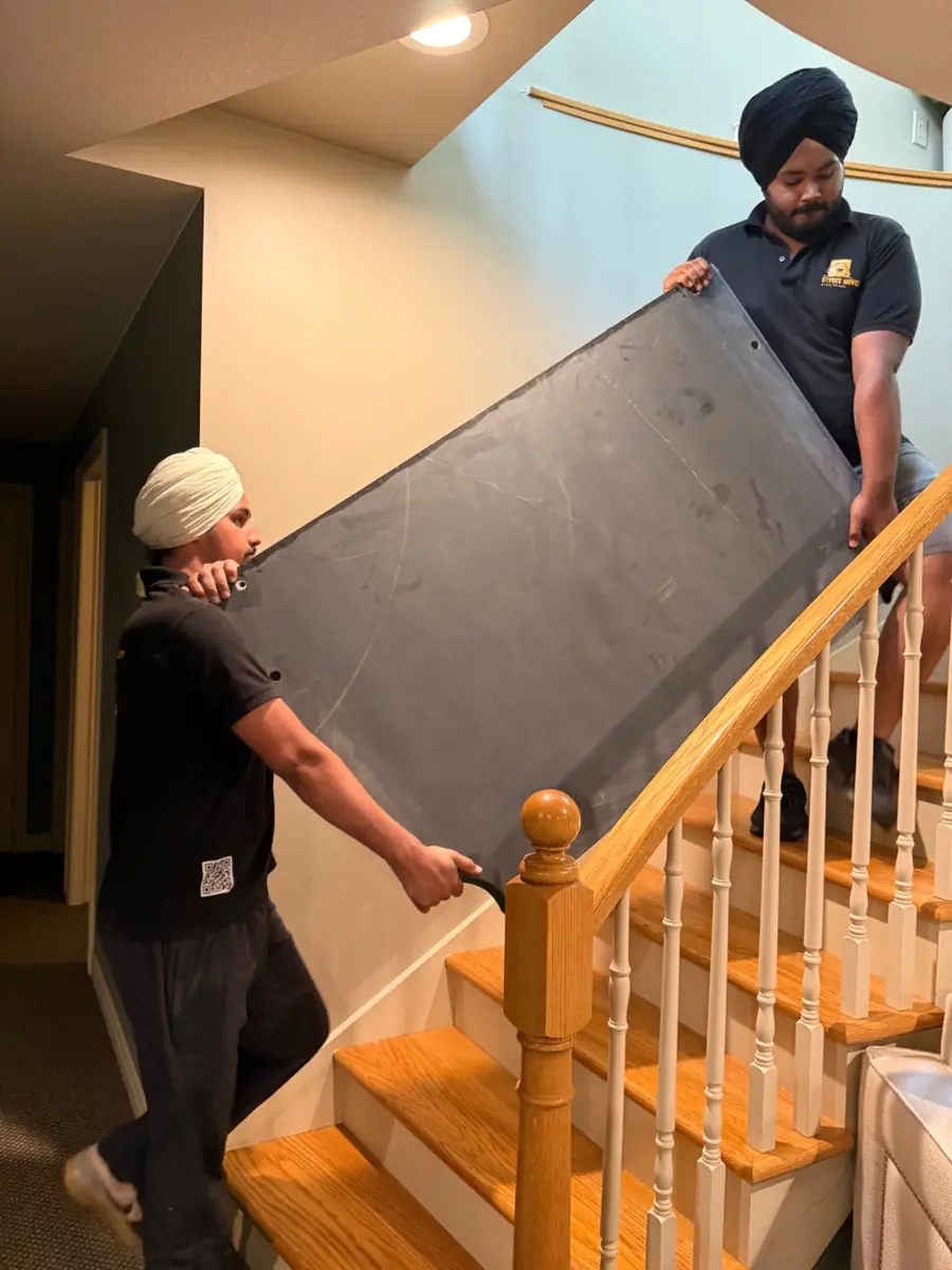 Gypsee Movers carrying a heavy pool table slate down stairs
