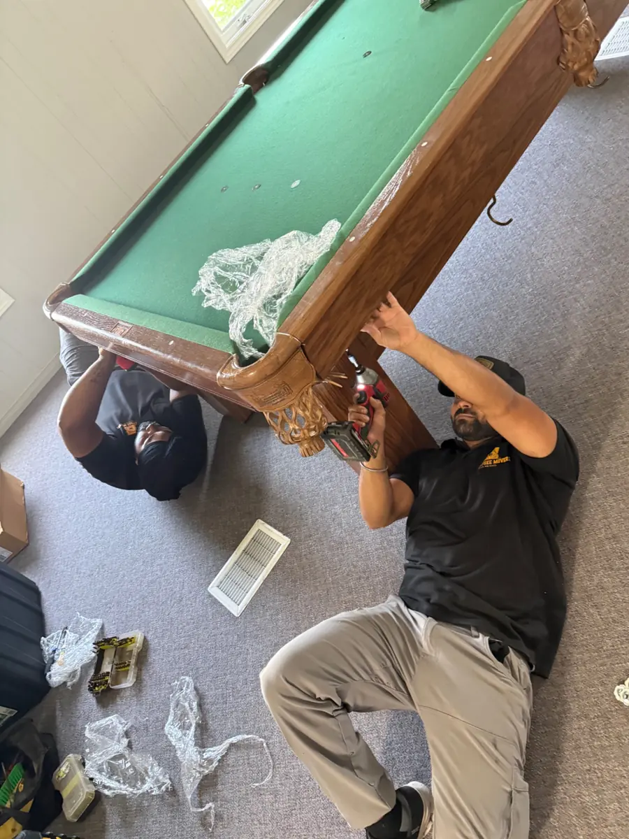 Gypsee Movers crew professionally disassembling a pool table