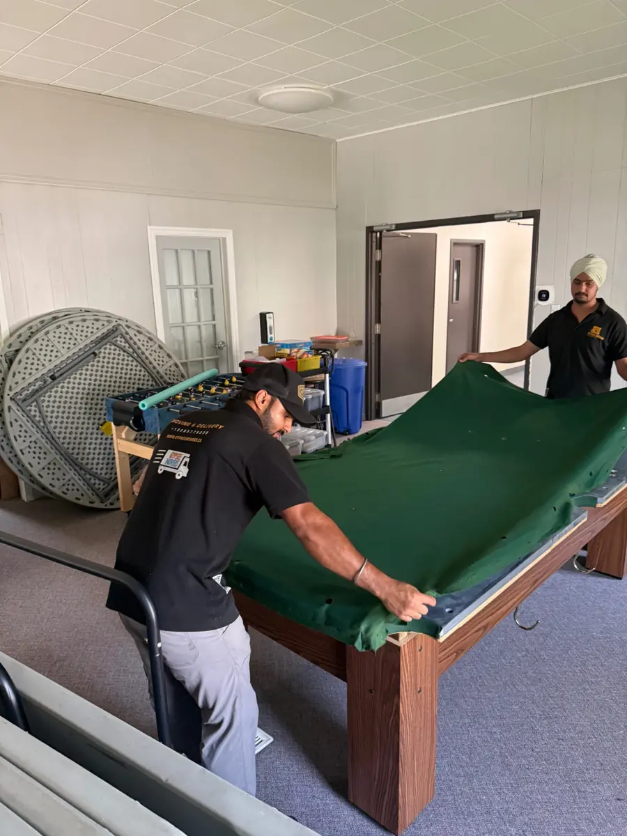 Old green pool table felt being removed for refelting
