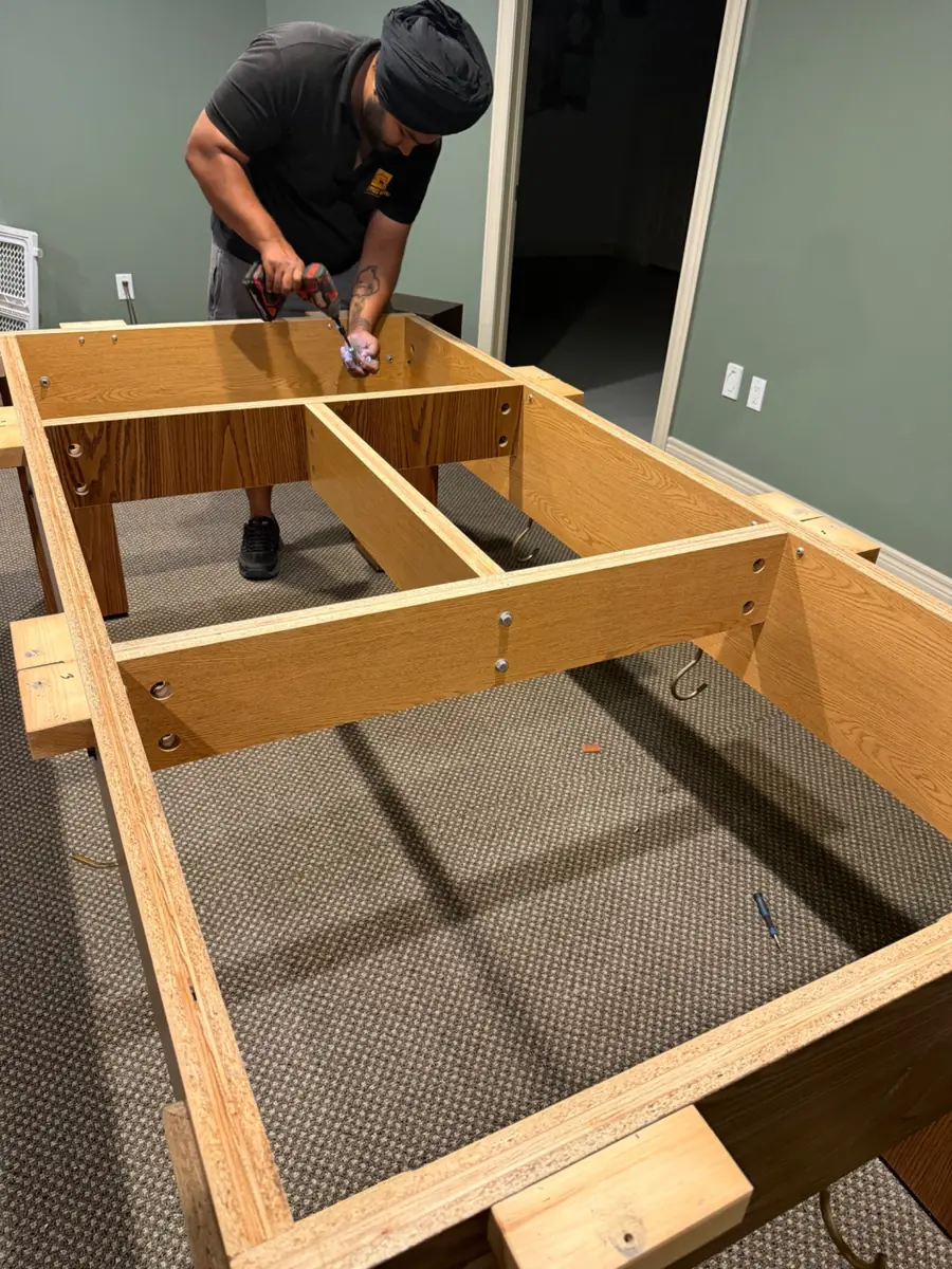 Pool table frame being dismantled for removal
