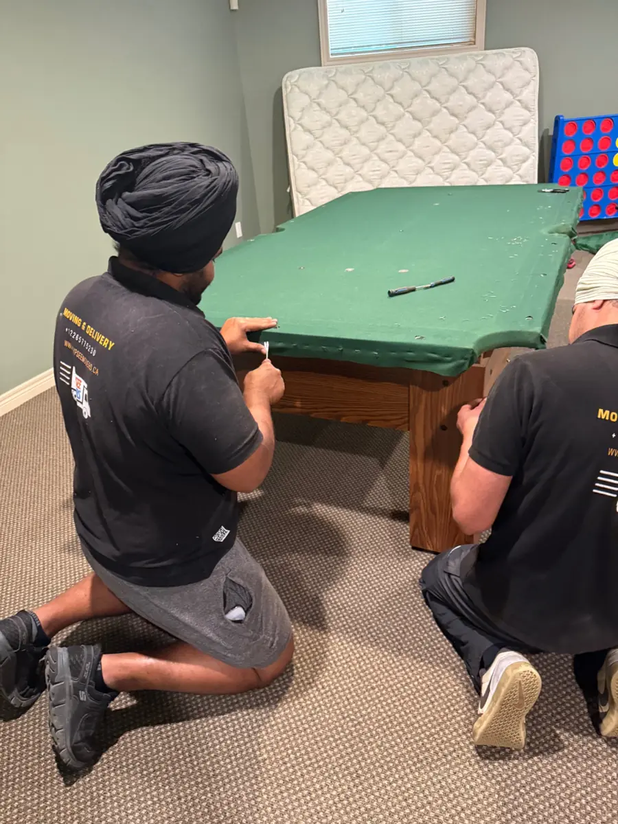Gypsee Movers carefully removing pool table felt and staples