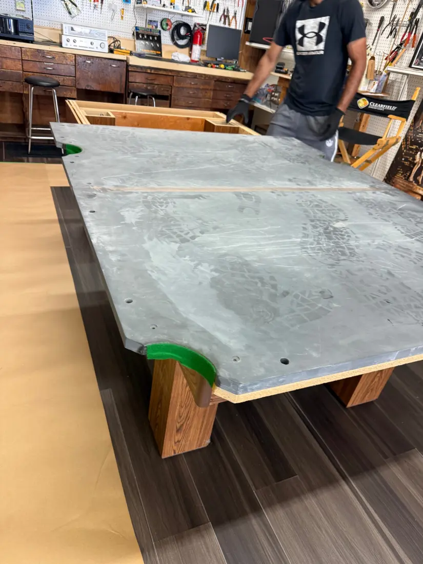Pool table slate section being positioned