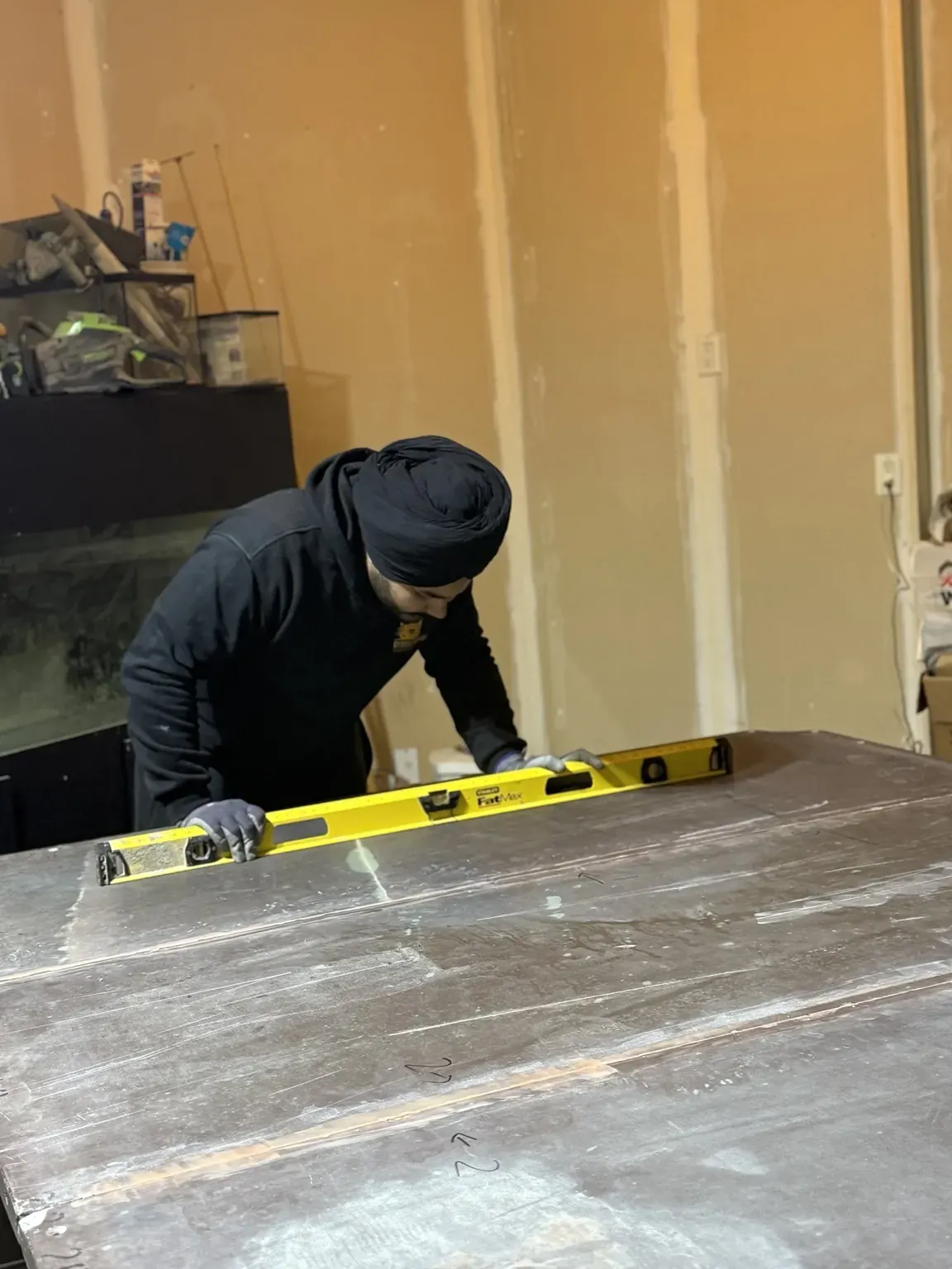 Gypsee Movers leveling a pool table with a level tool after assembly