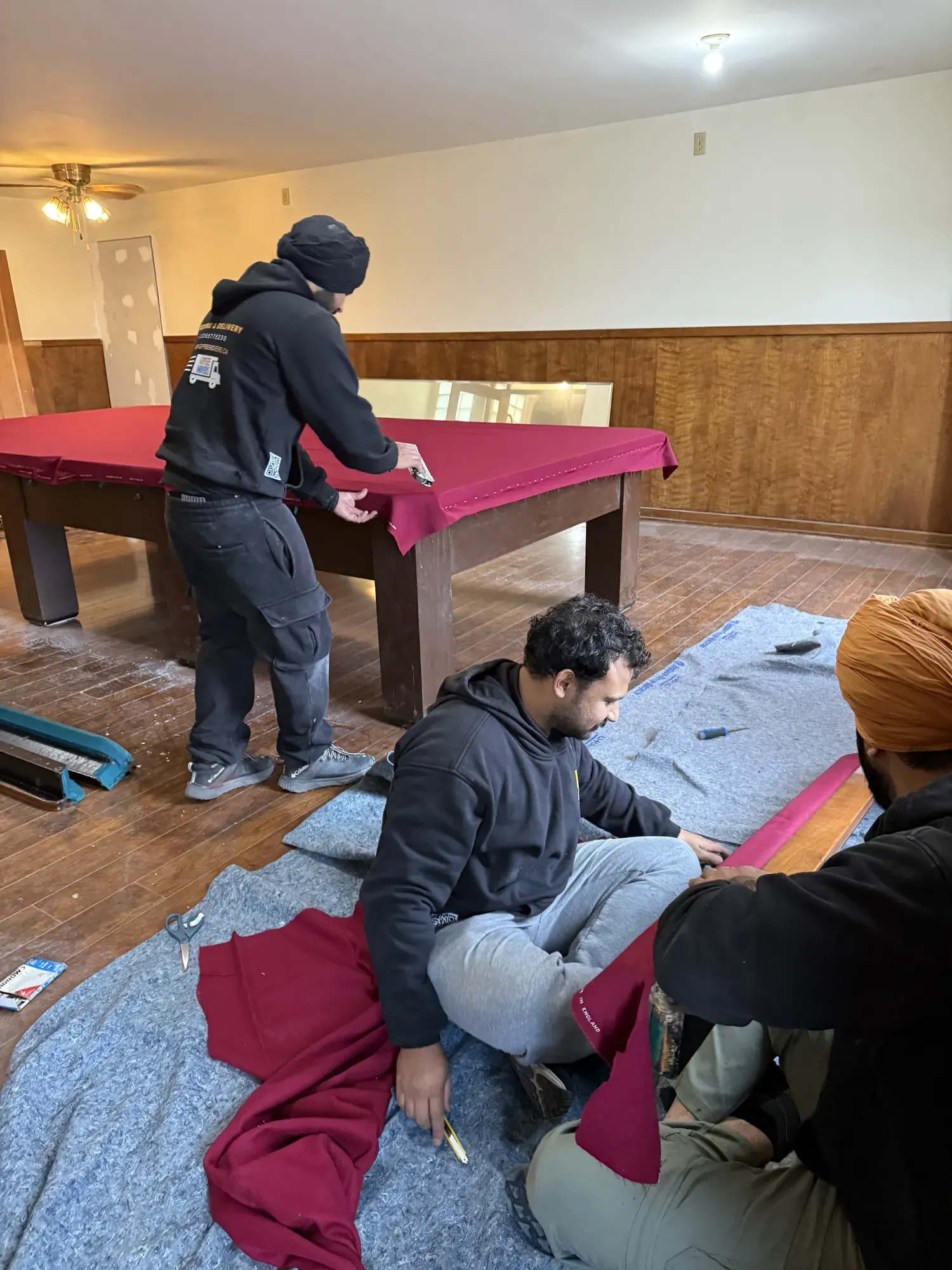 Gypsee Movers installing and stretching burgundy pool table felt