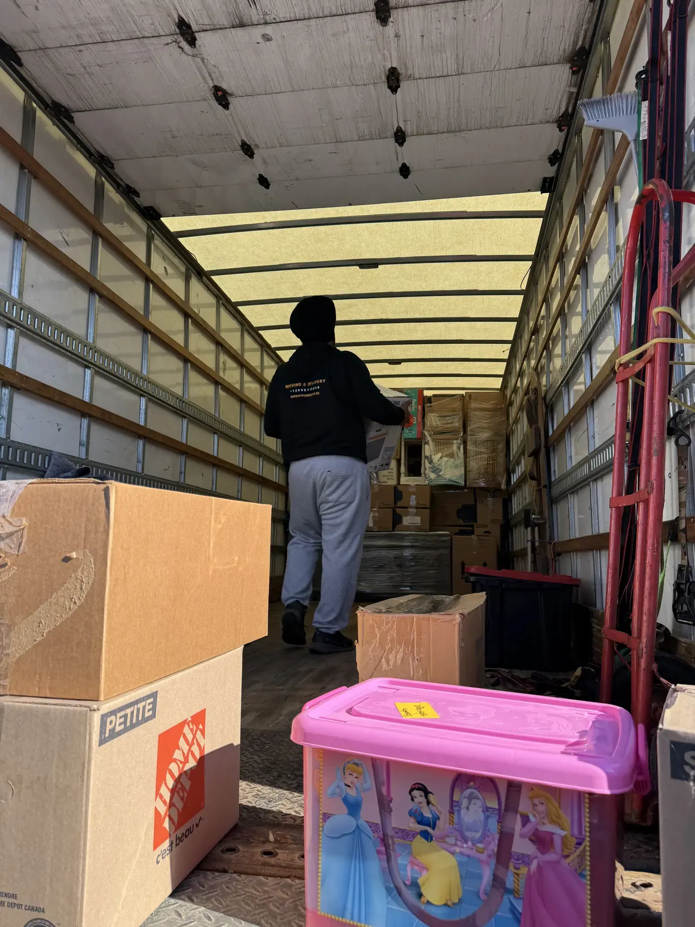 Movers carefully repositioning protected household furniture indoors