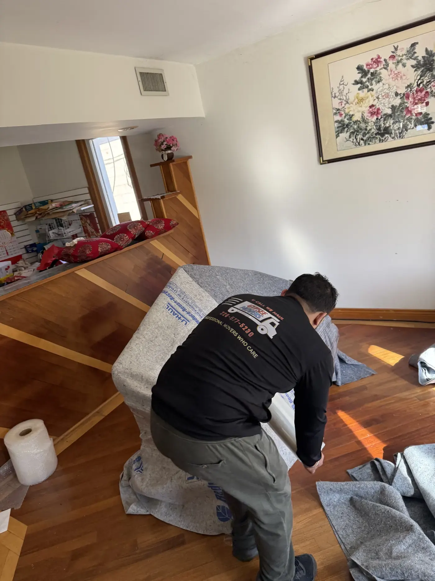 Residential movers carrying wrapped furniture outdoors during a London Ontario move
