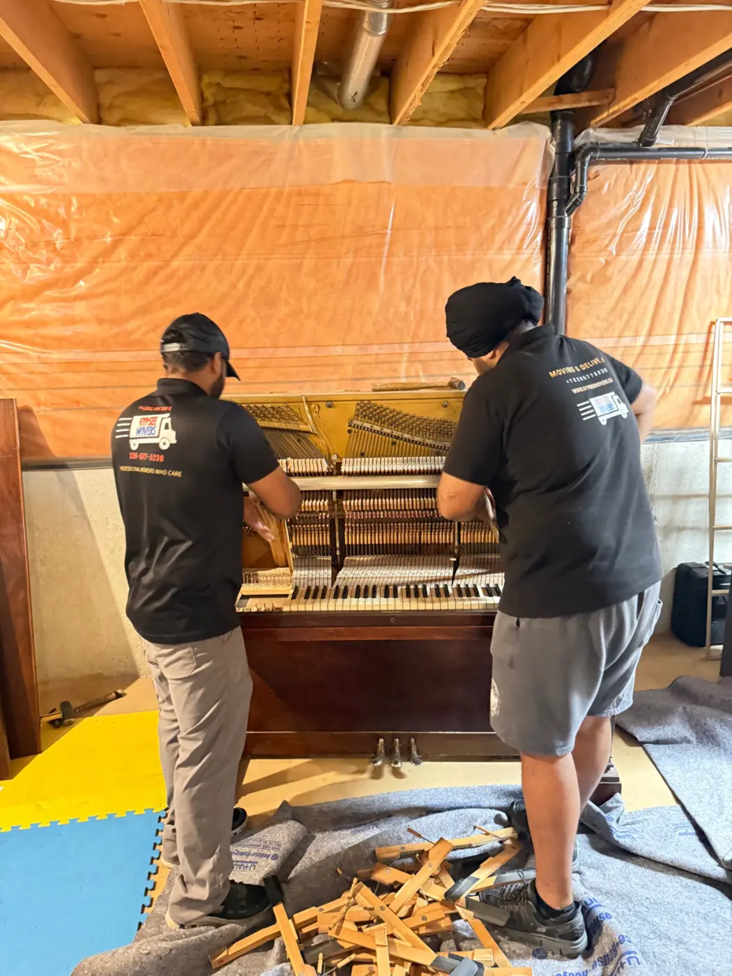 Gypsee Movers carefully disassembling an upright piano