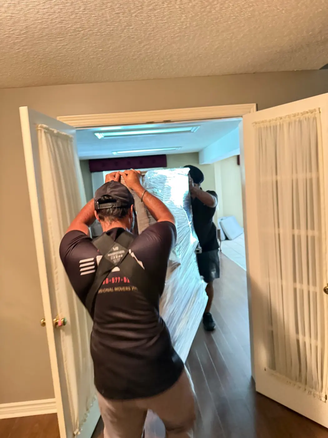 Movers using shoulder straps on a difficult piano route