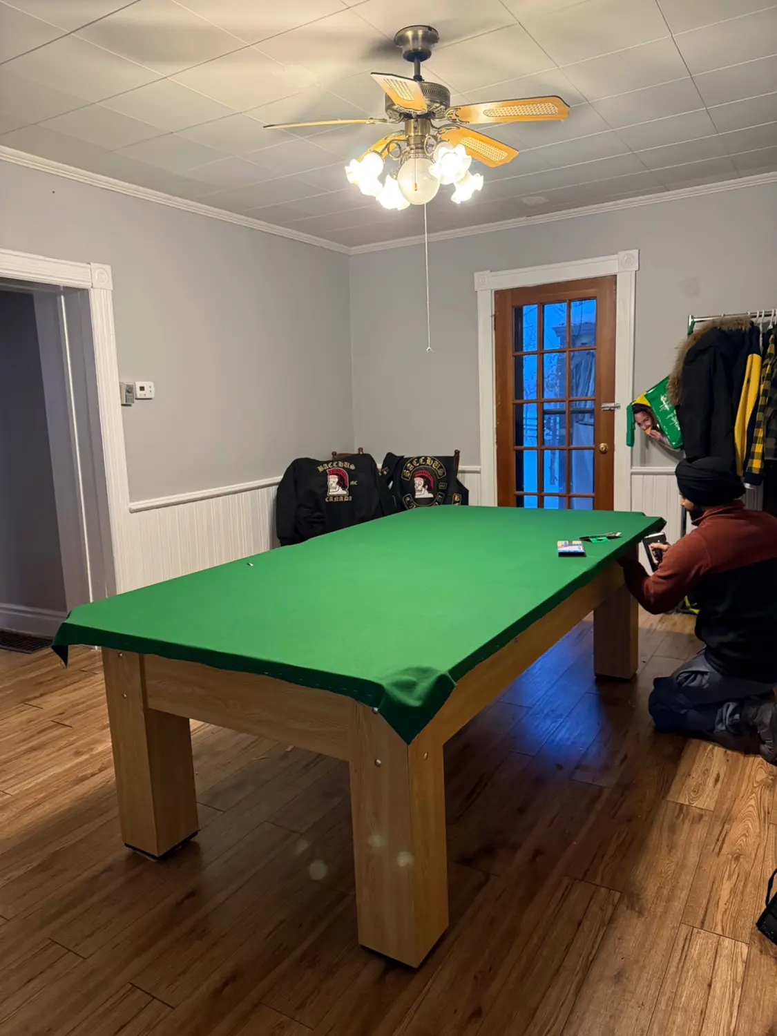Pool table technician installing green felt in a Stratford game room