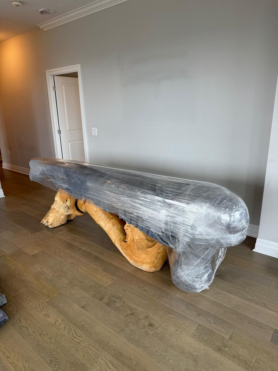Custom-made wooden furniture carefully wrapped in shrink wrap by Gypsee Movers for scratch-free moving protection